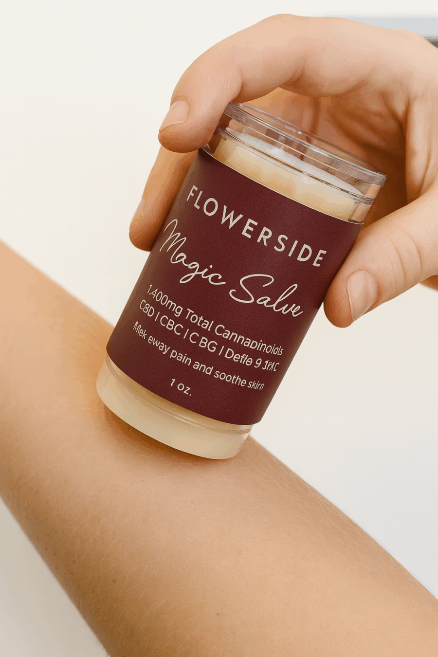 Hand applying Flowerside Magic Salve to forearm for topical relief on smooth, clean skin.