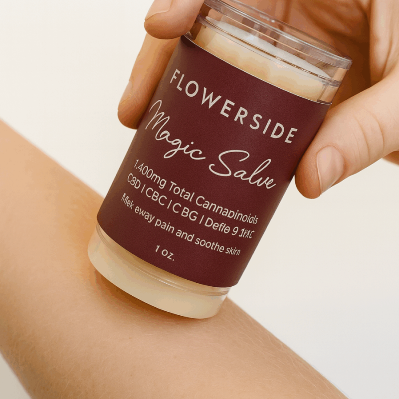 Hand applying Flowerside Magic Salve to forearm for topical relief on smooth, clean skin.